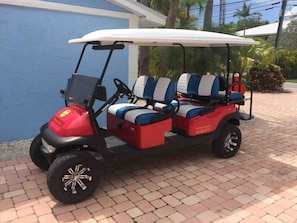 A golf cart with two seats, a canopy, and a logo on the side. - Walk to Beach, Siesta Key Villa 2, Pool View. Daily Rentals (Sarasota)