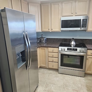 Enjoy cooking in this well-equipped kitchen with a refrigerator, microwave, oven, and toaster.