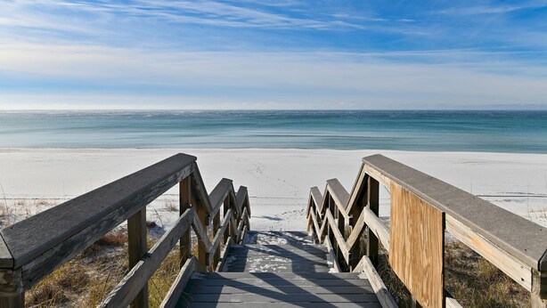 A wooden staircase leading to a beach with a clear sky. - 1 Bedroom Beachfront Condo Sleeps 6 (Destin)