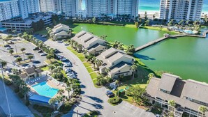 A resort with multiple buildings, a swimming pool, and a body of water. - 1 Bedroom Beachfront Condo Sleeps 6 (Destin)