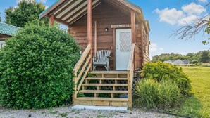 A wooden cabin with a porch, a chair, and a sign reading "GULL COTTAGE". - Waterfront 4 Bed 3 Bath Sleeps 8 - Free River Cruise with Week Long Rental (Heathsville)