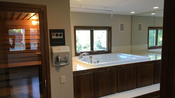 A modern bathroom with a large bathtub, a sink, and a window providing natural light. - Fabulous Minneapolis Townhome--Large Groups (Minneapolis)