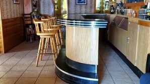 A wooden interior with a bar area, wooden chairs, and tiled flooring. - Papa’s Lake House, Quiet Retreat, Main Part Of Greater Bass Lake , Sleeps 12-14 (Greater Bass Lake)