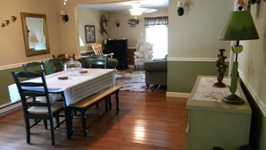 A dining area with a table set for four, wooden chairs, a bench, and a green plant on a side table. - Peace, quiet & relaxation!  Family friendly home. (Sugar Grove)
