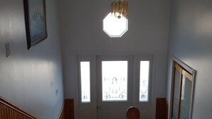 A staircase with wooden railings leading to a door with three windows. - Ocean Front House in Newfoundland (Cook's Harbour)