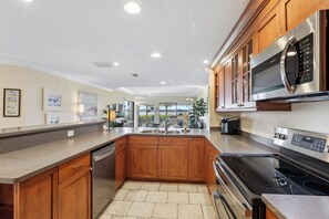 Une cuisine moderne avec des meubles en bois, des appareils en acier inoxydable et un grand îlot central.