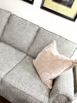 Relax in a serene space with a comfortable sofa and elegant artwork.