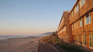 A beachfront hotel with a long, straight corridor leading to the beach.