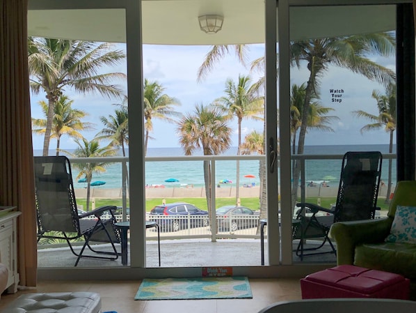 A room with a view of the beach, featuring two chairs and a small table. - Direct Oceanfront Luxury, Beautifully Redone! Satisfaction Guaranteed (Deerfield Beach)