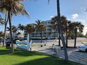 A beachfront hotel with palm trees, a swimming pool, and a parking area. - Direct Oceanfront Luxury, Beautifully Redone! Satisfaction Guaranteed (Deerfield Beach)