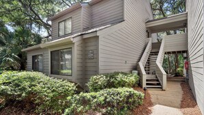 A two-story house with a small front porch, a staircase leading to a second level, and a mailbox with the number 2330. - Harbour Town Gem: Serene Lagoon Views & Steps to the Lighthouse (Hilton Head Island)