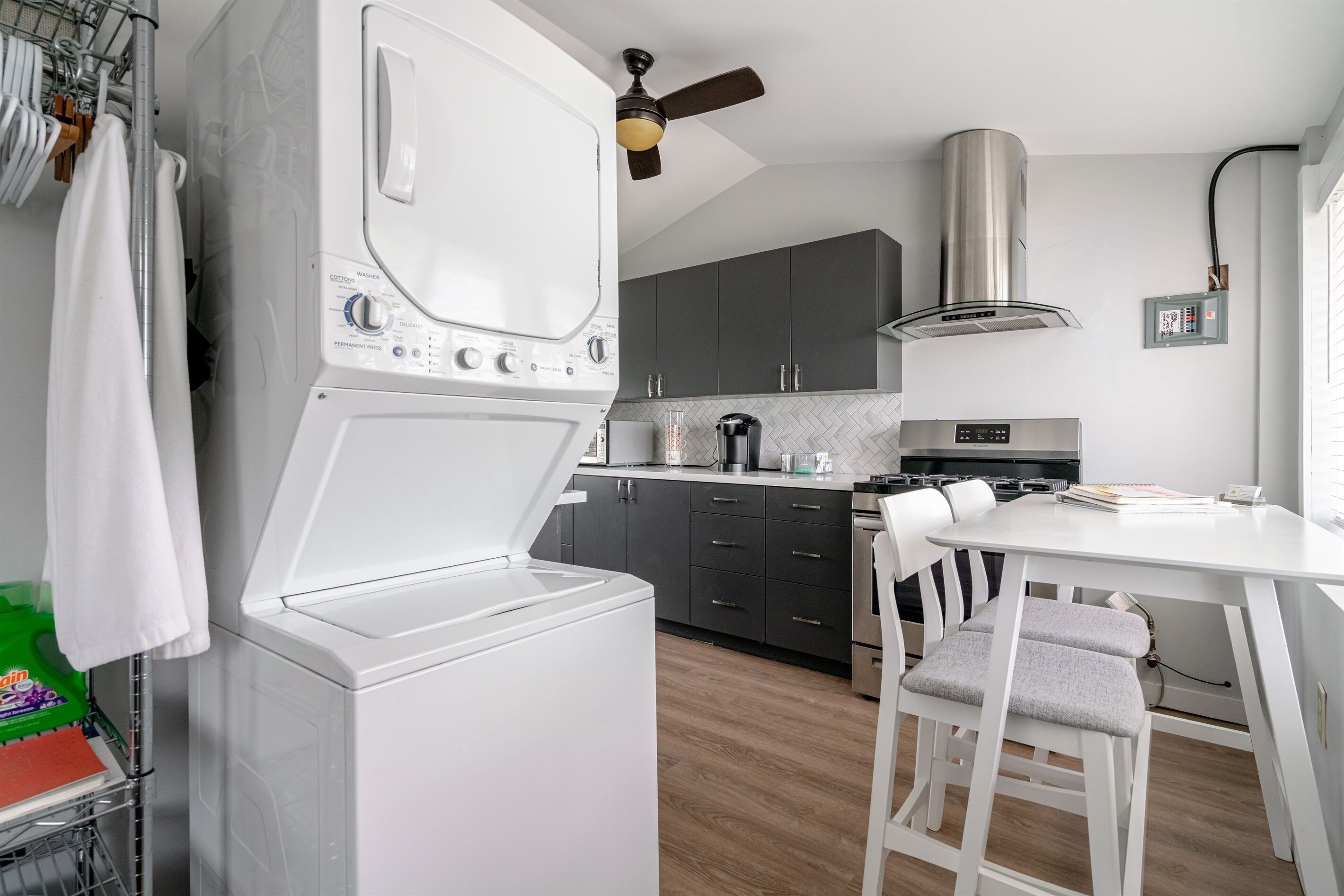 A compact kitchen with a built-in washer, a stove, and a dining area with a table and chairs.