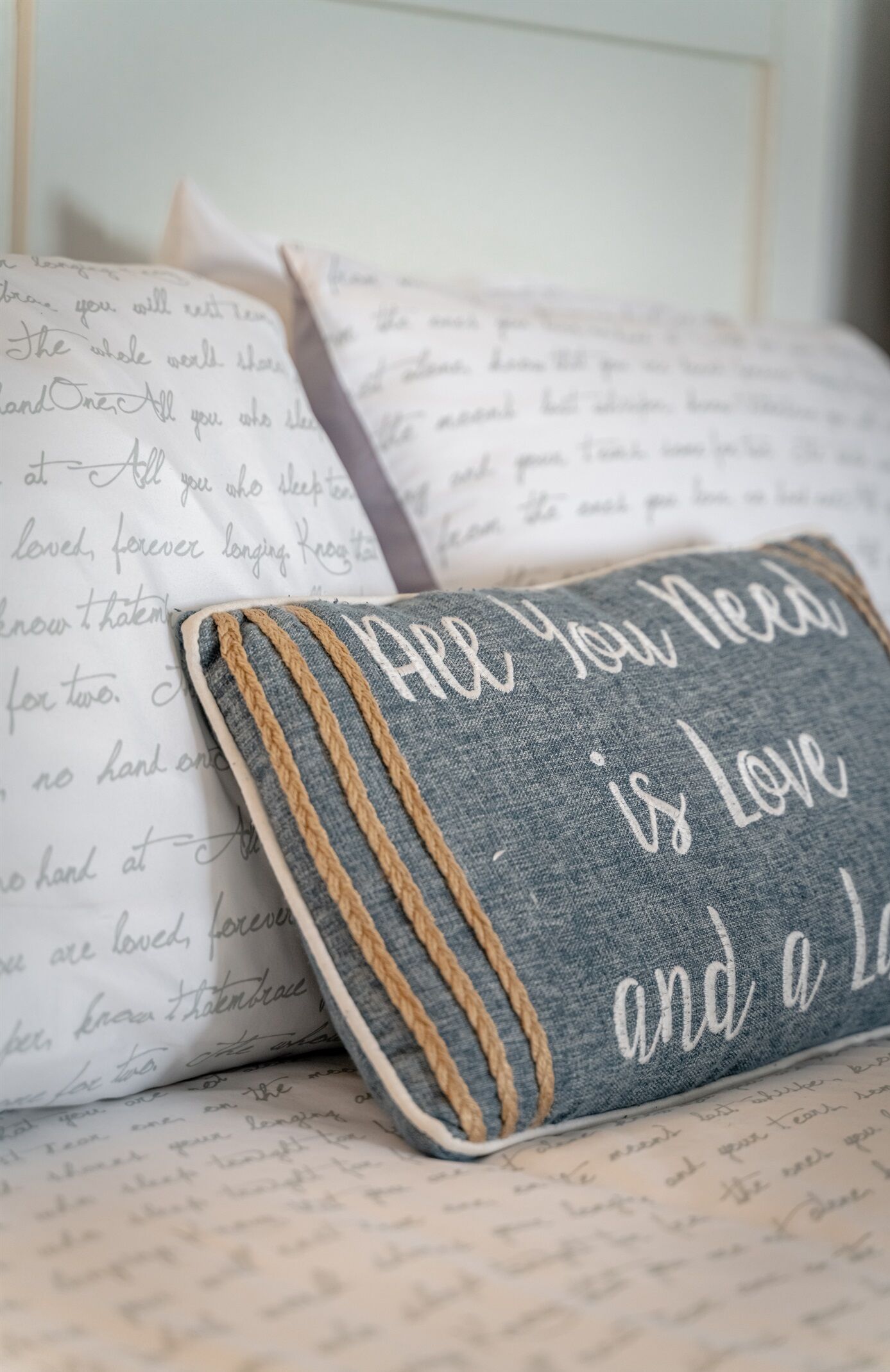 Un coussin orné d’une citation et un carnet contenant du texte écrit à la main.