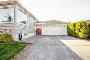 Uma casa com garagem, entrada de veículos e gramado bem cuidado.