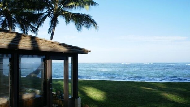 A beachfront property with a covered patio overlooking the ocean.