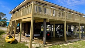 Ein zweistöckiges Haus mit einer Veranda und einem kleinen Deck.