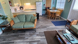 Ein Wohnzimmer mit einer Couch, einem Couchtisch und einem Essbereich mit Stühlen.