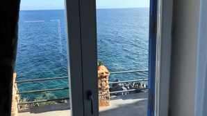 A view of the sea through a window with a stone wall and metal railing. - Hotel L’Ariana ISOLE EOLIE - UNA Esperienze (Leni)