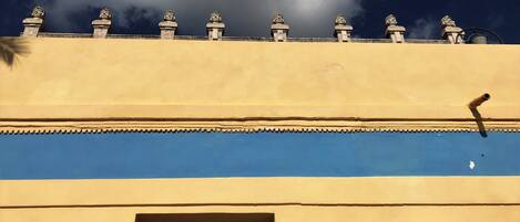 Een gebouw met een blauwe deur en een raam, afgecrown met beelden.