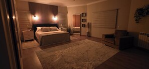 A bedroom with a bed, bedside tables, a nightstand, a dresser, a chair, a large rug, and a closet with a sliding door. - Luxury 4 bedroom villa (Monte Francisco)