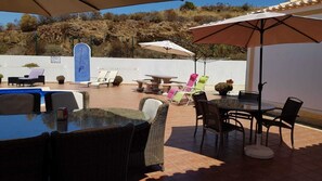 An outdoor patio with a pool, lounge chairs, and umbrellas. - Luxury 4 bedroom villa (Monte Francisco)