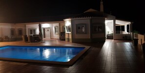 Relax by the pool in a serene outdoor space with a patio and comfortable seating.
