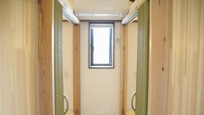 En smal hall med träväggar och ett fönster längst in.