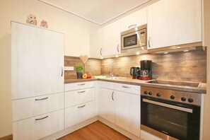 Enjoy cooking in this kitchen with sleek cabinetry, stainless steel oven, and a coffee maker.