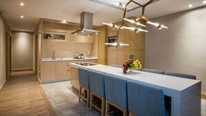 Una cocina moderna con una isla central, electrodomésticos integrados y una lámpara de techo original.
