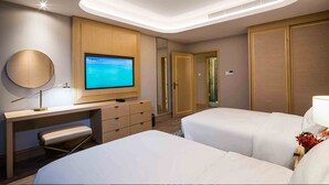 Una habitación de hotel con cama, escritorio con televisor, espejo y armario.