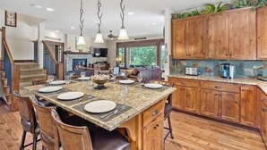 A spacious kitchen with a large island, wooden cabinets, and a stone backsplash. - Golf View, Hot Tub, Suncadia Pool Access (Cle Elum)