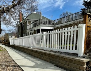 Situated in a suburban neighborhood, this two-story house features a spacious balcony and a charming picket fence.