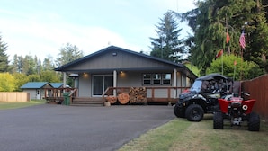 A two-story building with a covered porch and a driveway. - Direct Dune Access Sleeps 10 In House, 6 In BunkHouses - Bath Houses. (North Bend)