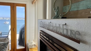A fireplace with a sign reading "My Favorite Beach House" and a decorative mirror above it. - The BEST of the best on Mission Bay! (San Diego)