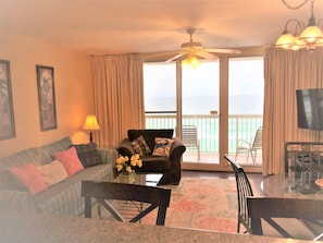 Relax in this stylish living room with a sofa set, coffee table, and dining area, offering a view of the ocean.