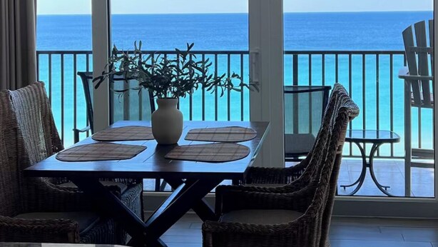 Un balcon équipé d’une table à manger, de chaises et d’un luminaire suspendu.