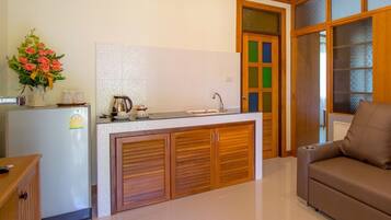 A compact kitchen with a central island, a refrigerator, and a sink.