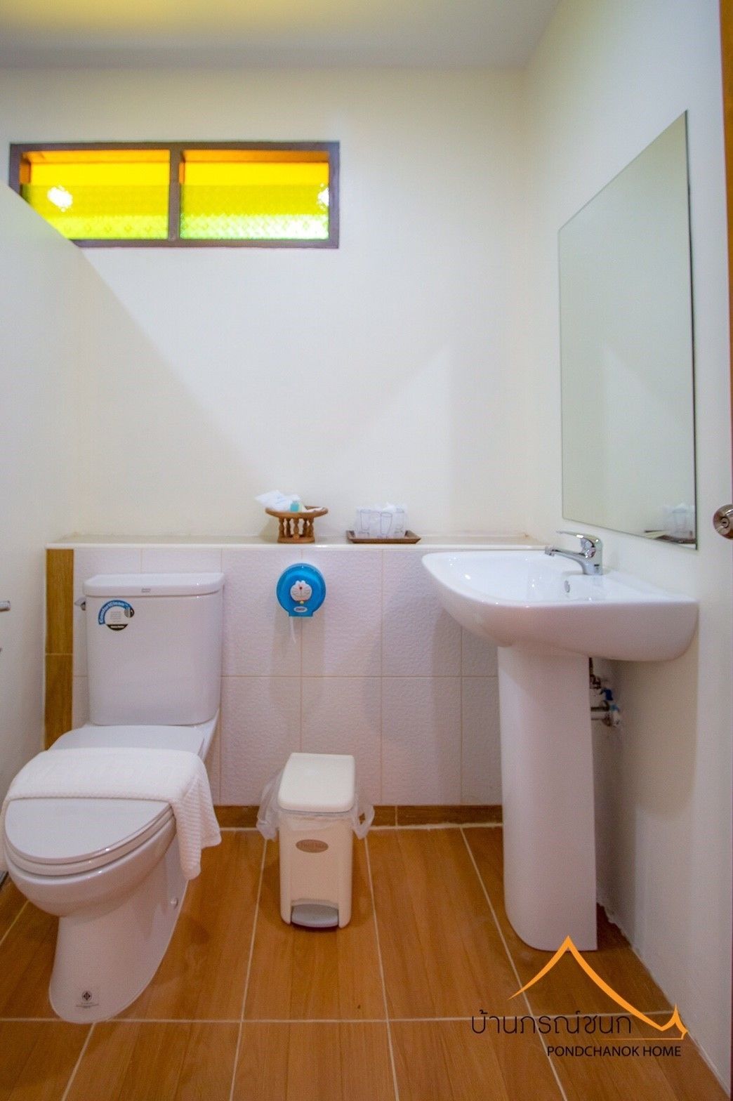 A bathroom with a toilet, bidet, sink, and a window above the toilet.
