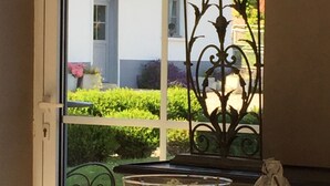 Une table sur laquelle se trouve un saladier en verre contenant un dessert, un oiseau décoratif et une lampe.