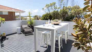 Enjoy dining al fresco on the deck surrounded by lush greenery and trees.