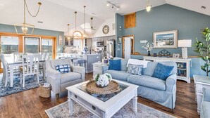 A spacious living room with a large window, a dining area, and a kitchen.