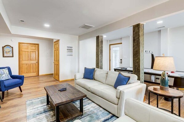 A modern living room with a sofa, armchairs, a coffee table, and a lamp. - Legacy | 980 ft from the beach | Dog Friendly, Private Pool, Hot Tub | Corolla (Corolla)