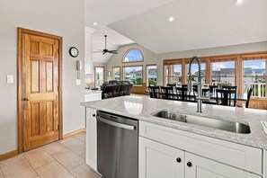 Une cuisine dotée d’un grand îlot central, d’un lave-vaisselle et offrant une vue sur le quartier.