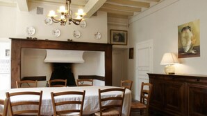 A dining room with a round table, six wooden chairs, a chandelier, and a cabinet with a lamp. - Very nice mansion in Fiac (Lavaur) near Toulouse (Fiac)