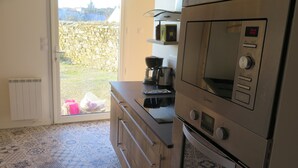 A kitchen with a built-in oven, microwave, and coffee maker.