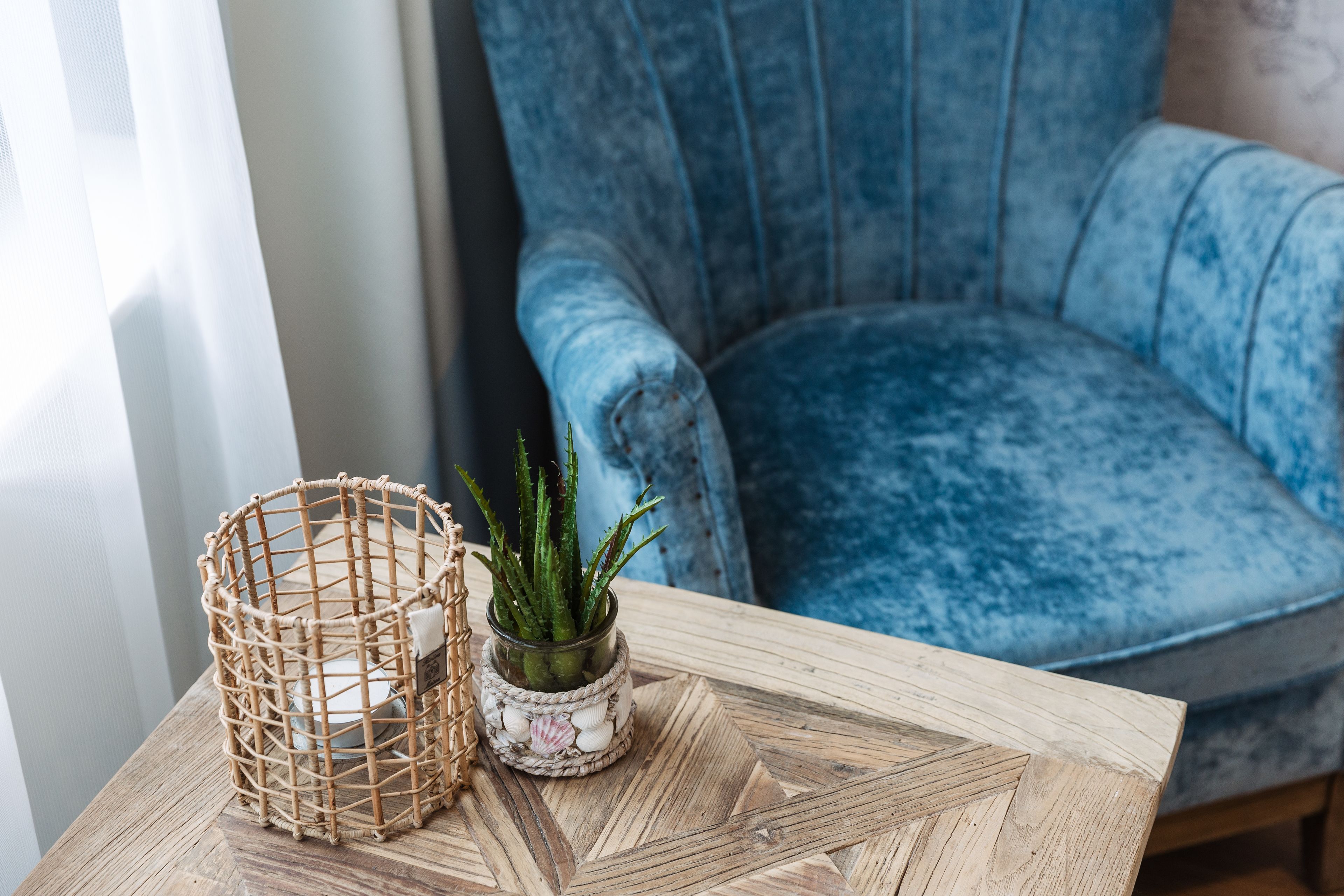 A wooden table with a woven basket and a small potted plant.