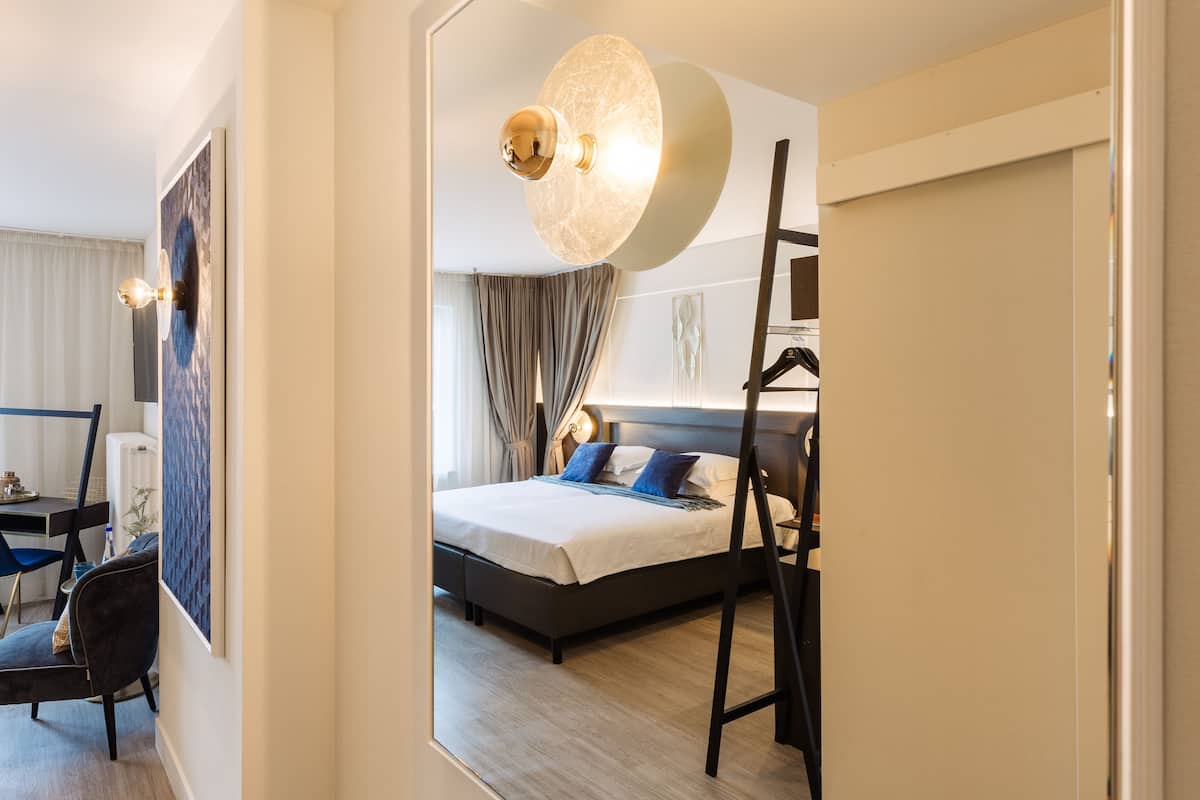 Una habitación de hotel moderna con una cama grande, un escritorio y una silla.