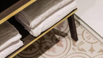 A bathroom with a white sink, a wooden vanity with a mirror, and a patterned floor.