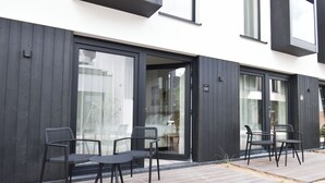 Un bâtiment moderne doté d’un patio avec des espaces aménagés pour s’asseoir à l’extérieur.