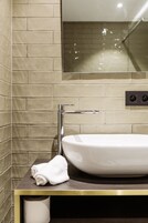 A bathroom with a white sink, a towel, and a toilet paper holder.